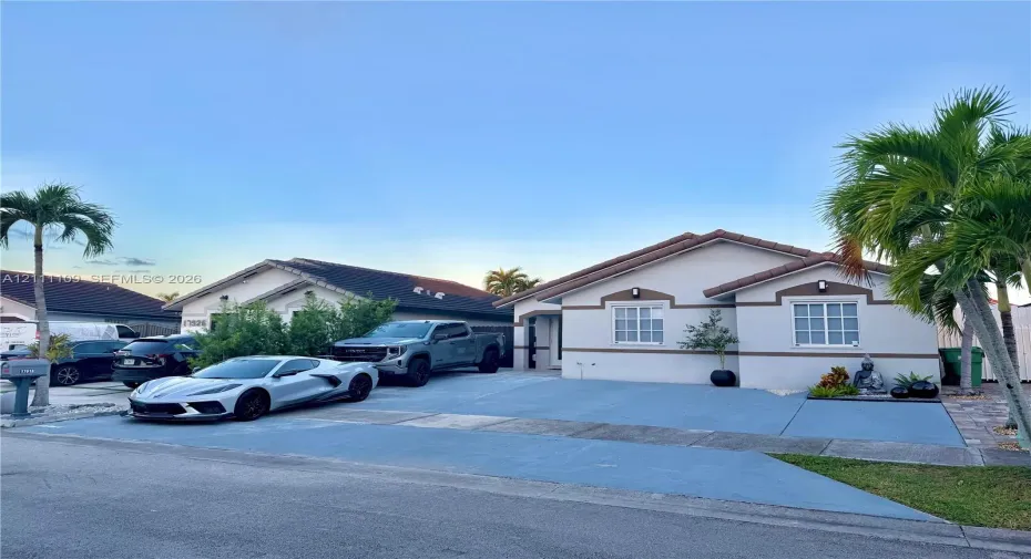 Single-story residence featuring a stucco exterior, multi-pane windows, a tiled roof, and a paved concrete driveway