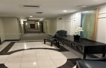 Common area featuring stone tile flooring with decorative inlay, wall molding detail, and recessed ceiling lighting