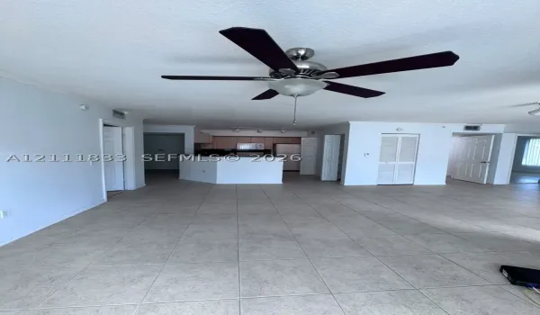 Ceramic tile flooring, ceiling fan with integrated lighting, kitchen peninsula, and louvered closet doors