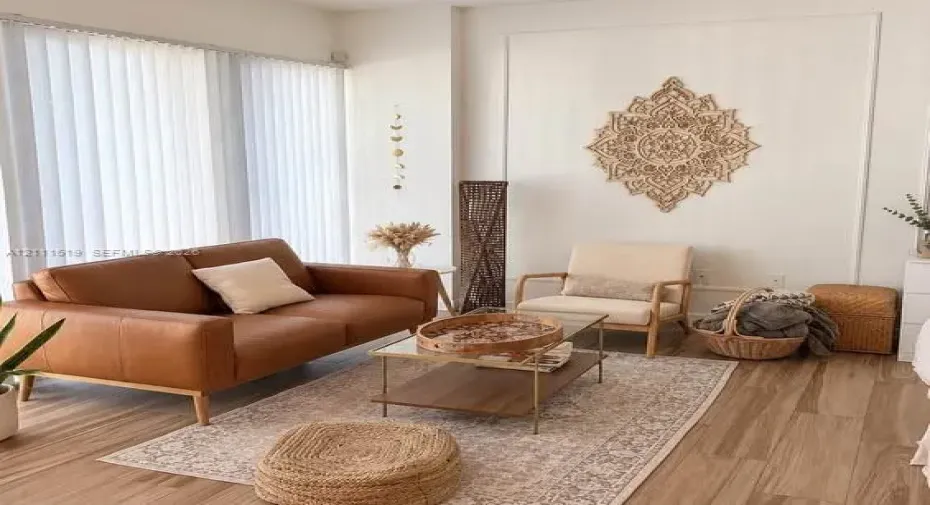 Room featuring wood-finish flooring, white walls with decorative molding, and floor-to-ceiling vertical blinds