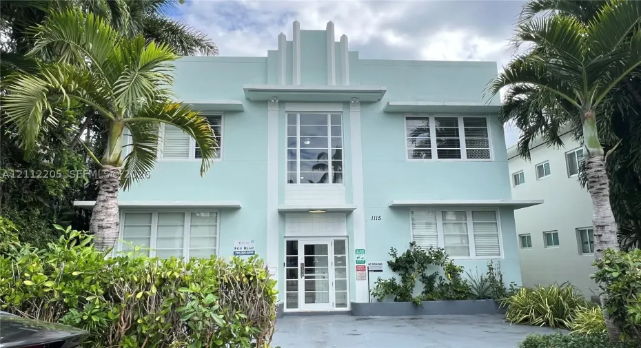Art Deco exterior featuring a stepped roofline, multi-pane windows, horizontal structural bands, and a glass-paneled entry door