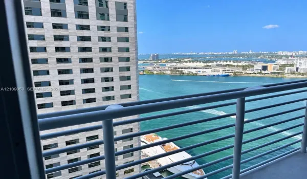 Elevated balcony featuring a metal railing with a clear horizon line encompassing the waterfront, harbor, and urban skyline
