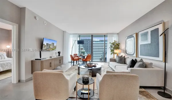 Living area featuring floor-to-ceiling windows, access to a private balcony, and light-toned tile flooring