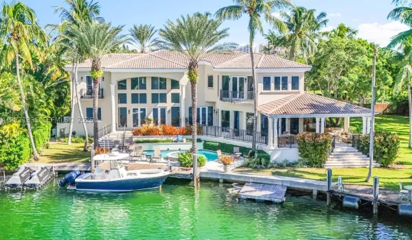 Two-story waterfront residence featuring a tile roof, private boat dock, swimming pool with integrated spa, and covered terrace