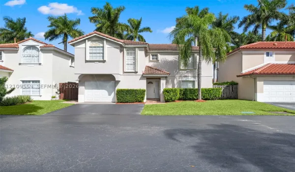 Stucco exterior featuring a clay tile roof, multi-pane windows, and an attached one-car garage