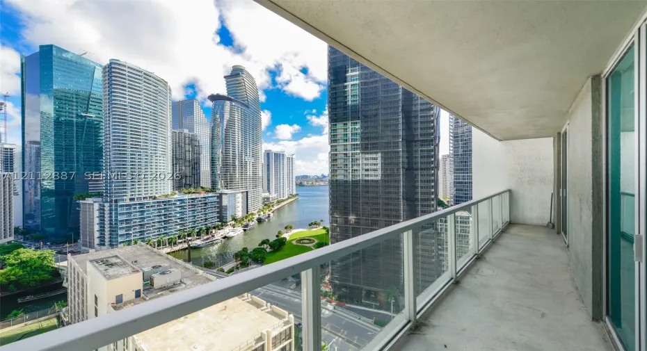 Private balcony featuring a concrete floor and a glass-paneled railing
