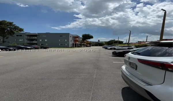 Asphalt surface parking lot featuring designated stall markings and pole-mounted exterior lighting