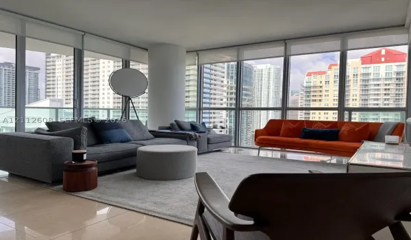 Floor-to-ceiling windows, ceramic tile flooring, and a structural column