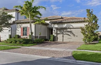Mediterranean-style exterior featuring tiled roof & decorative shutters.