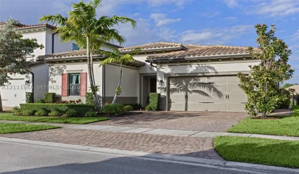 Mediterranean-style exterior featuring tiled roof & decorative shutters.