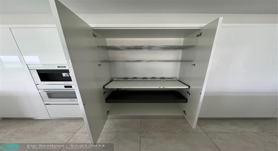 Concealed shelving with electricity for counter appliances and additional storage.