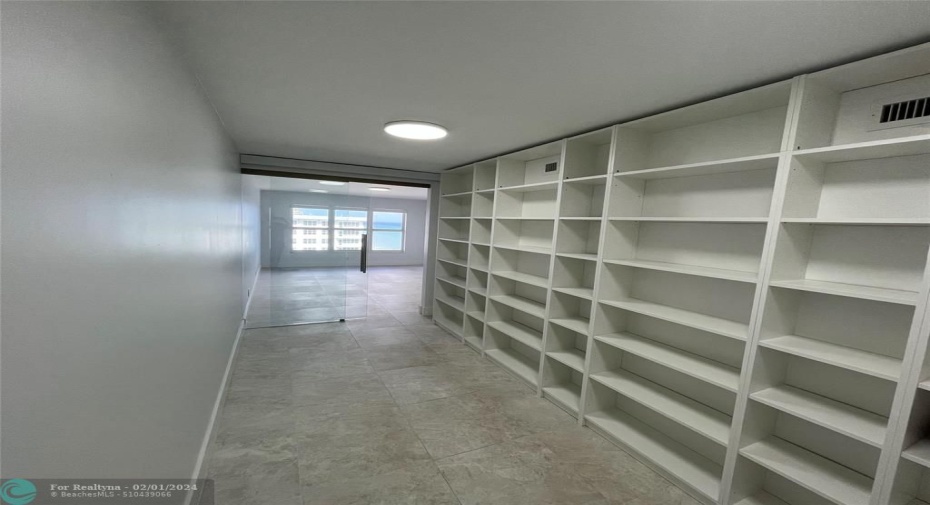 The room features wall-to-ceiling built-in shelving.