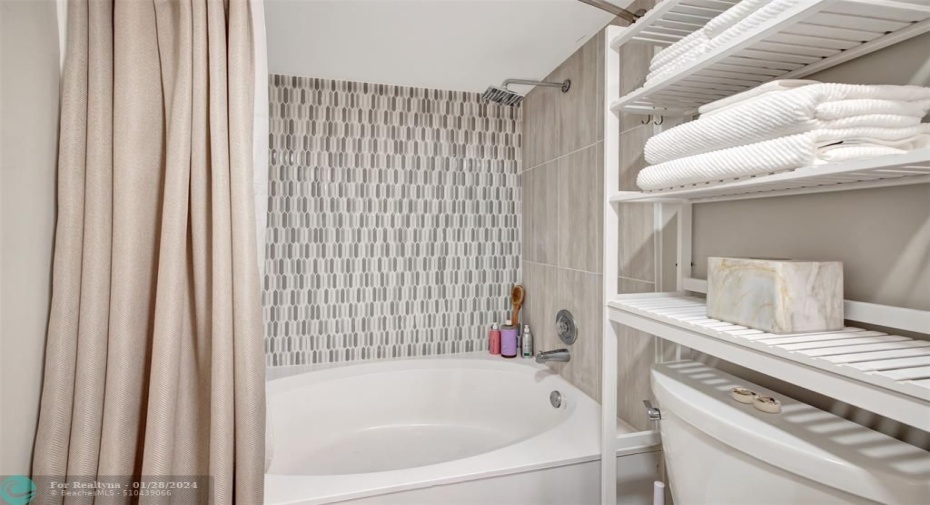 Primary Bedroom En-Suite Bathroom with refinished tub and new backsplash tiling.