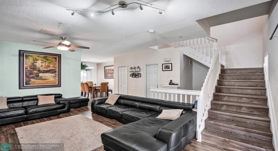 Family room on 2nd floor looking towards kitchen to the left & 3rd floor staircase to the right.