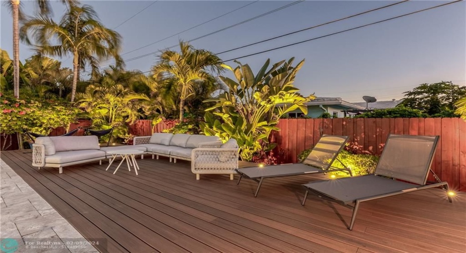 Tropical Fenced in Private Backyard with Heated Pool, uplighting, outdoor dining table, lounge chairs