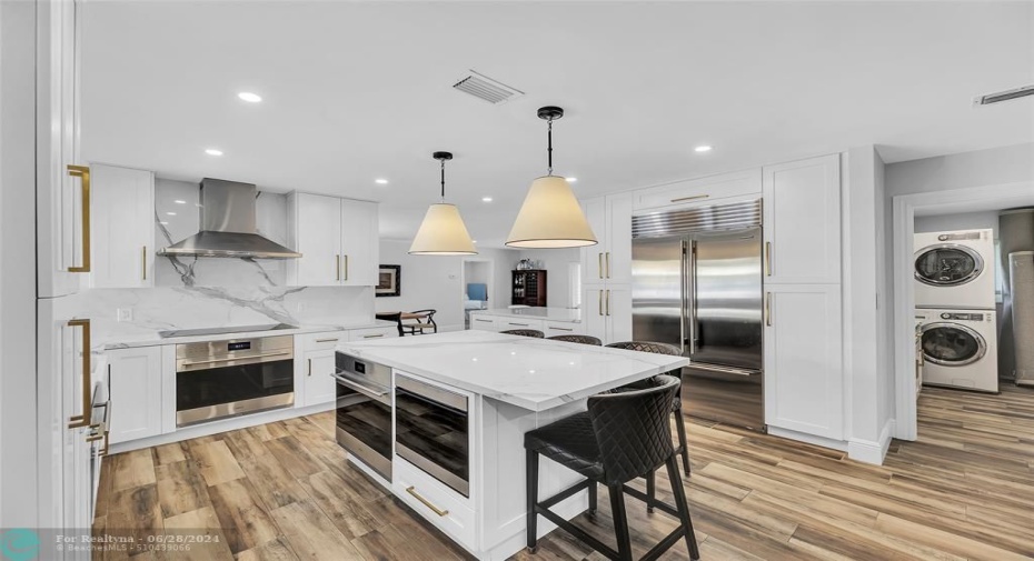 Kitchen features white shaker cabinets, Thick quartz counters and stainless appliances