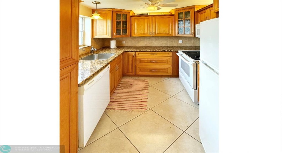 Updated Kitchen features Wood Cabinets, Granite Counters & Tile Backsplash