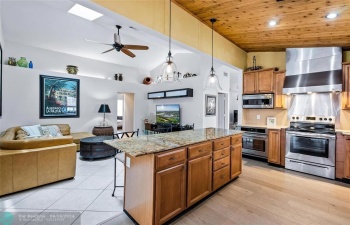 Kitchen with wood cabinetry, center Island, two ovens, range rood, subzero refrigerator and lots of storage.