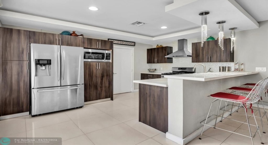 Tray Ceiling with recessed lights, Stainless Steel Appliances, Sleek and Modern wood cabinets, Quartz countertops with polished porcelain tiles. This kitchen needs to be seen in person to truly appreciated how well it comes together