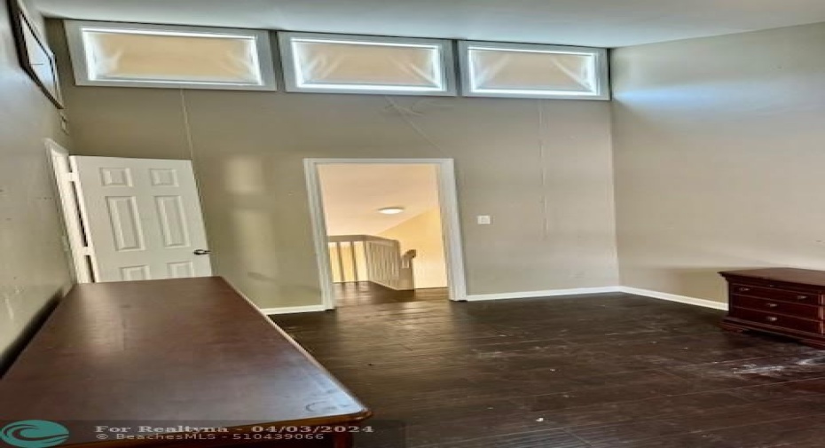 second floor bedroom with high ceilings and clerestory lights