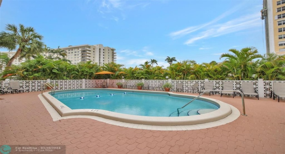 COMMUNITY POOL WITH CHAIRS AND PATIO AND BBQ AREA