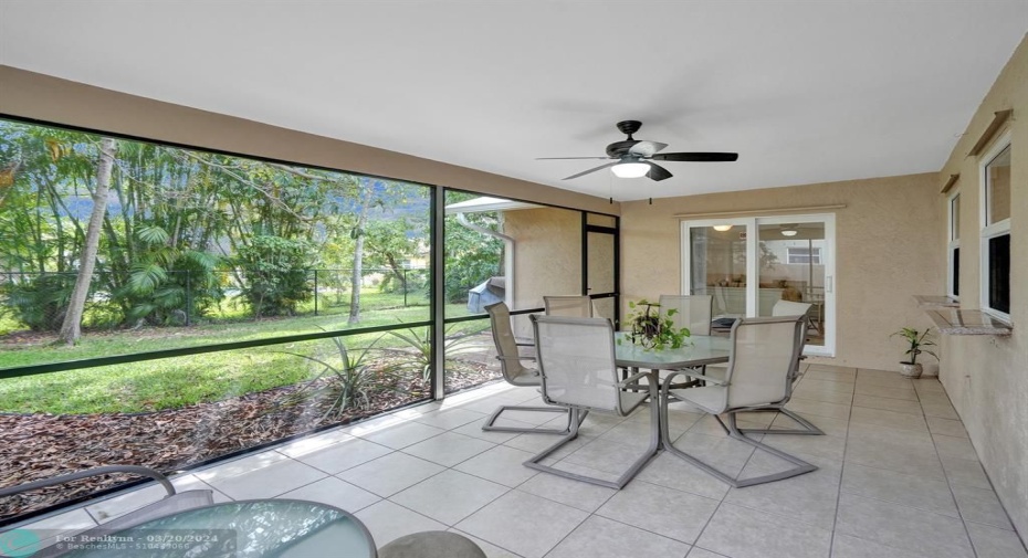 Screened in patio with beautiful lush backyard with fruit trees.