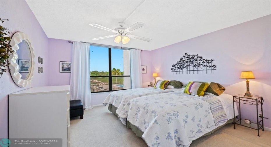 Second bedroom with a view of the pool and golf course