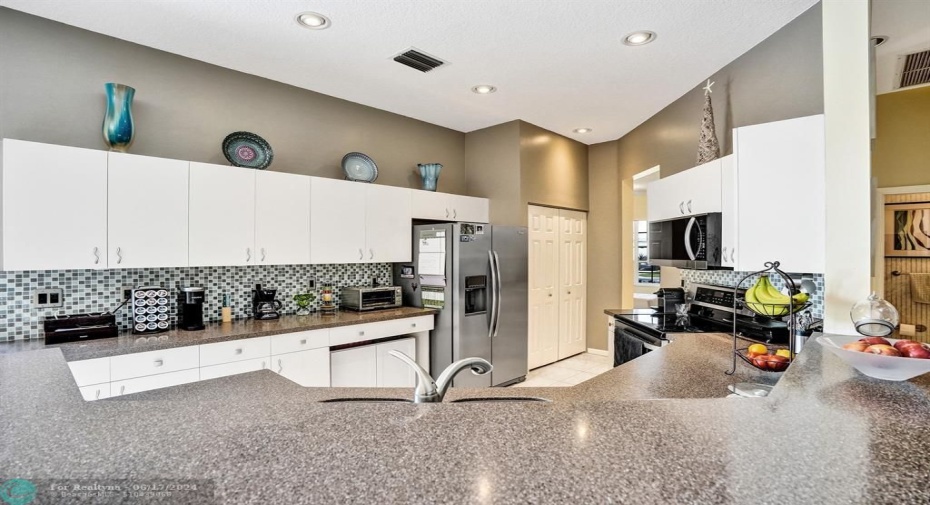 Modern Touches:  The sleek Corian countertops, installed in 2019, add a touch of modern elegance and provide a durable and easy-to-maintain surface for all your culinary creations.  Imagine prepping meals on these pristine countertops, the smooth surface and neutral tones creating an atmosphere of sophisticated style.