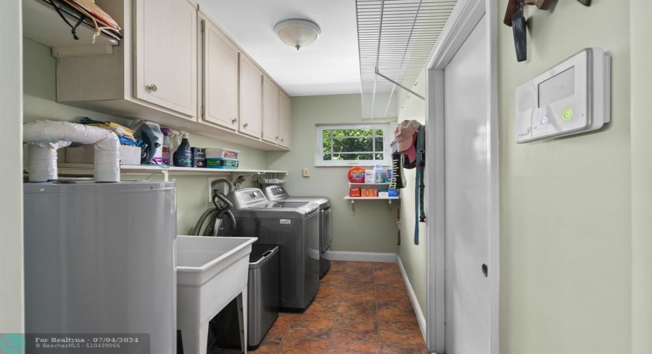 Laundry room off of kitchen has plenty of storage and a mud sink!