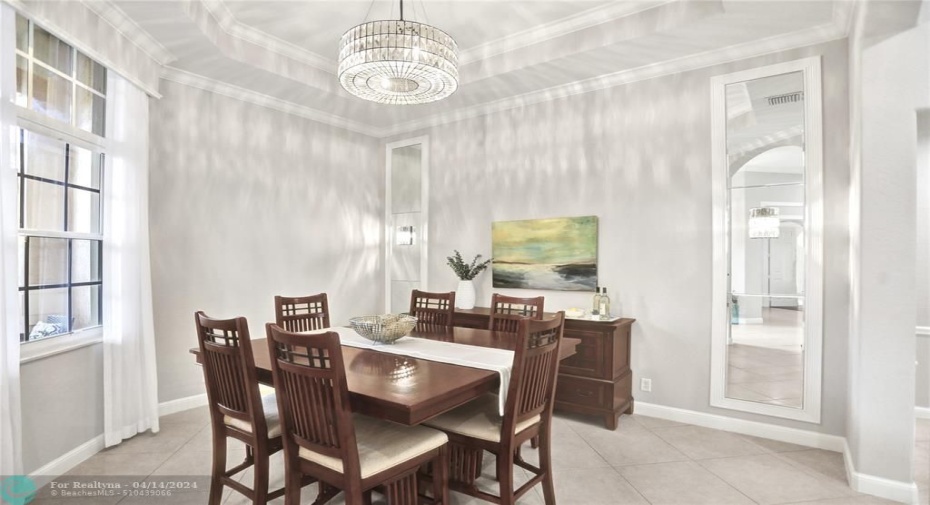 Gracious formal dining room with custom mirrors that reflect the sparkling chandelier lights.