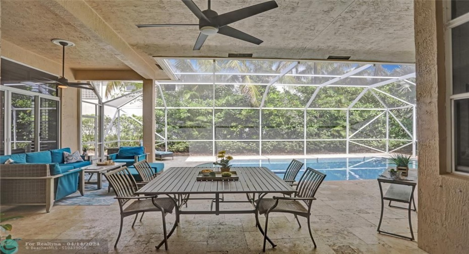 Generous covered patio new travertine marble pool deck, two newer ceiling fans, screened for year-round comfort.