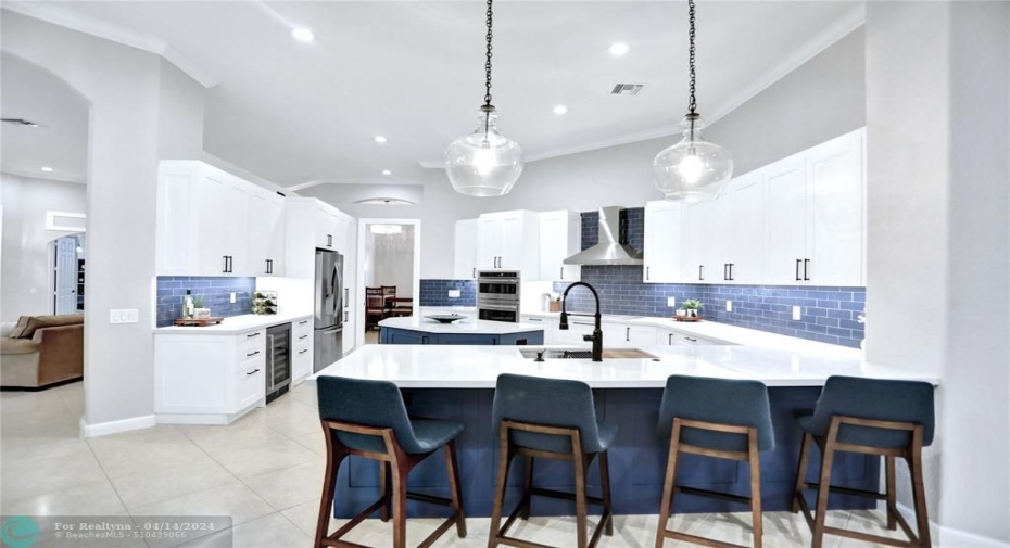 Newly remodeled chef's kitchen with dual tone solid wood cabinetry, induction oven, hood, wine refrig, custom tile backsplash, high-end stainless appliances, quartz counters,