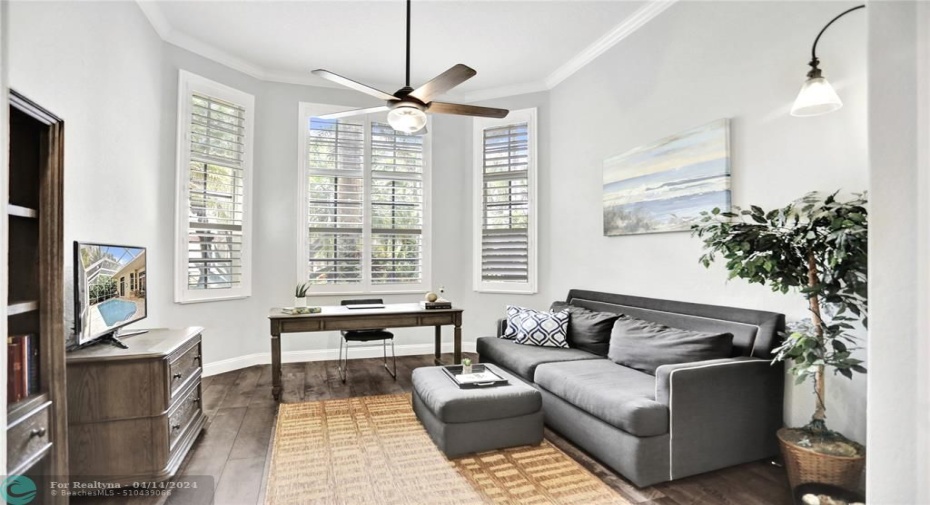 Framed by 3 large windows, the home office with closet was renovated in 2020 to create a comfortable work space; luxury vinyl plank flooring, new paint, new light sconces, new ceiling fan, new baseboards.