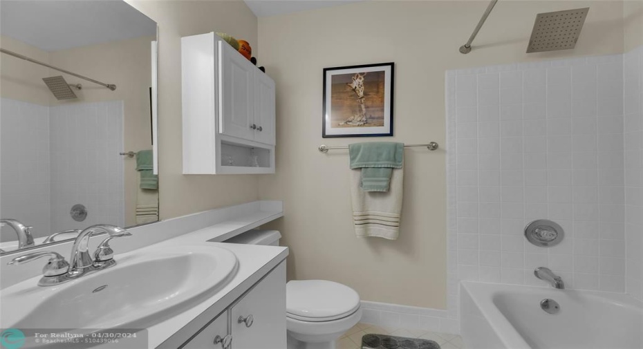 Second bathroom offers a tub/shower combo and white cabinets