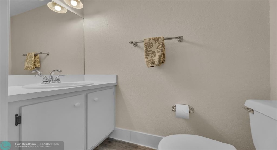 Half bathroom with white cabinets and vanity