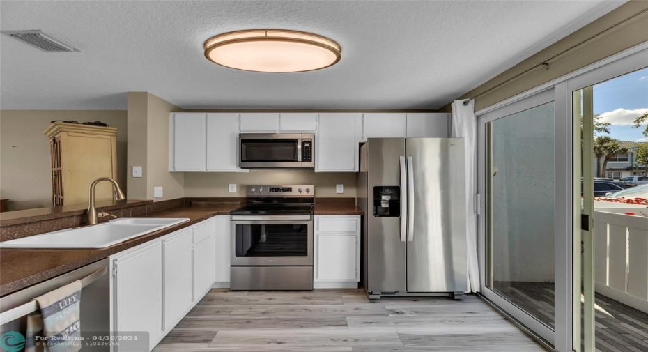 Spacious kitchen with great natural light and sliders out to front porch