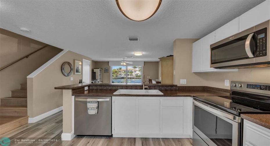 Kitchen is open and offers amazing water views and stainless steel appliance with white cabinets.