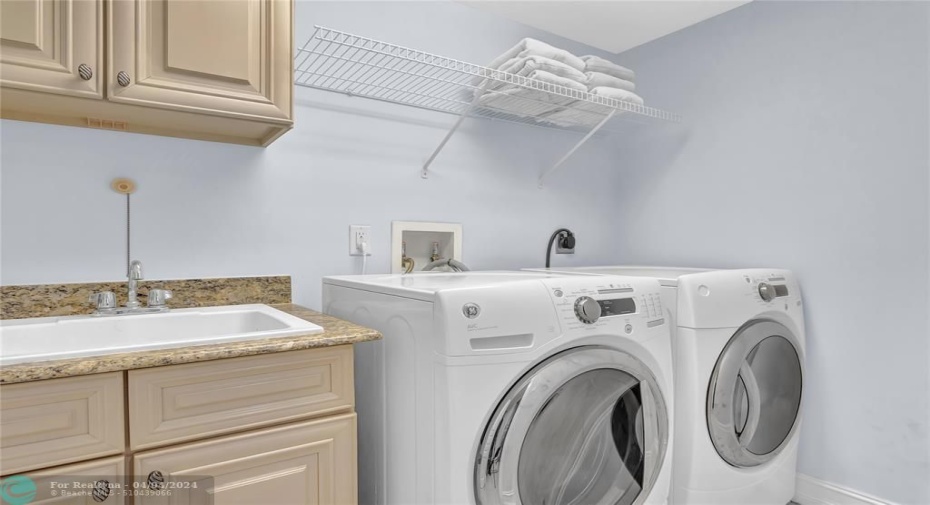 Laundry room with sink and cabinets.