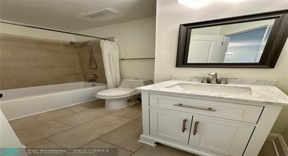 Guest featuring new tiles, toilet, vanity , faucets, mirror and lighting