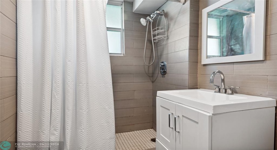Renovated bathroom with light from you impact window in the shower.
