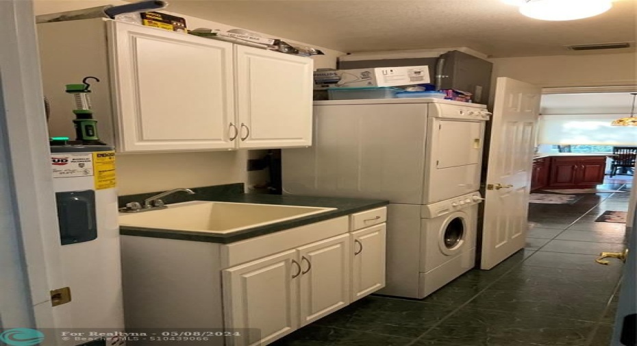 Inside laundry room with cabinet and large pantry closet