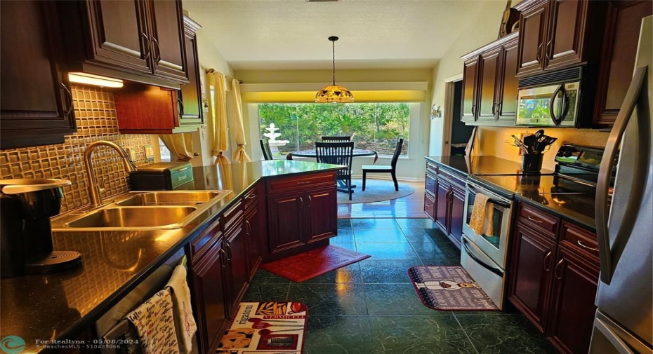 Kitchen with solid cherry cabinets, stainless steel appliances, quartz countertops and tile floors