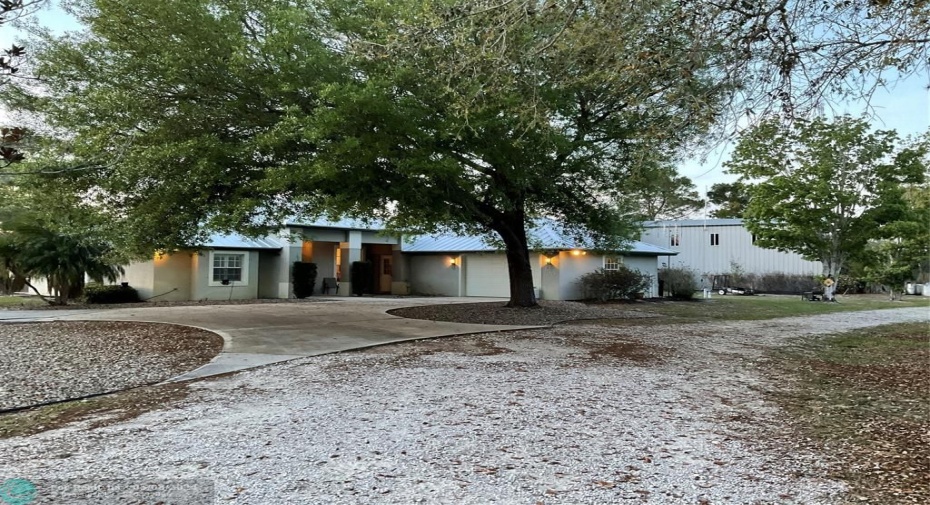 Front view with side garage and metal building