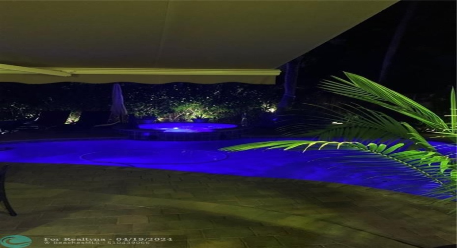 POOL AREA SEEN FROM LIVING ROOM AT NIGHT