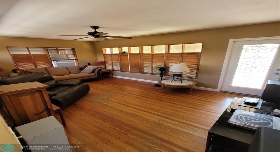 Living room with hardwood flooring and custom-made wooden bifold shutters