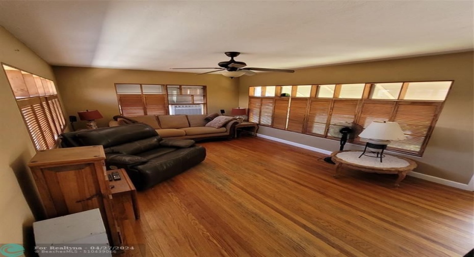 Living room with hardwood flooring and custom-made wooden bifold shutters