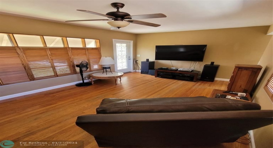 Living room with hardwood flooring and custom-made wooden bifold shutters