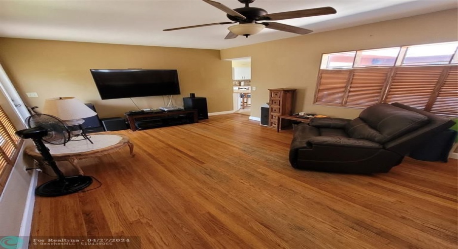 Living room with hardwood flooring and custom-made wooden bifold shutters