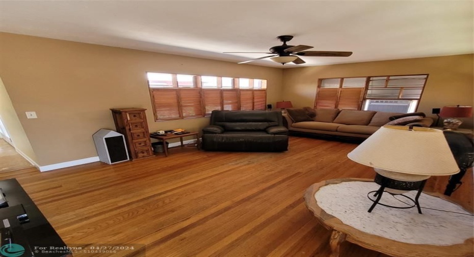 Living room with hardwood flooring and custom-made wooden bifold shutters