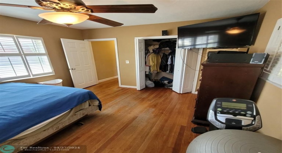 Primary bedroom hardwood flooring and plantation shutters (partial)